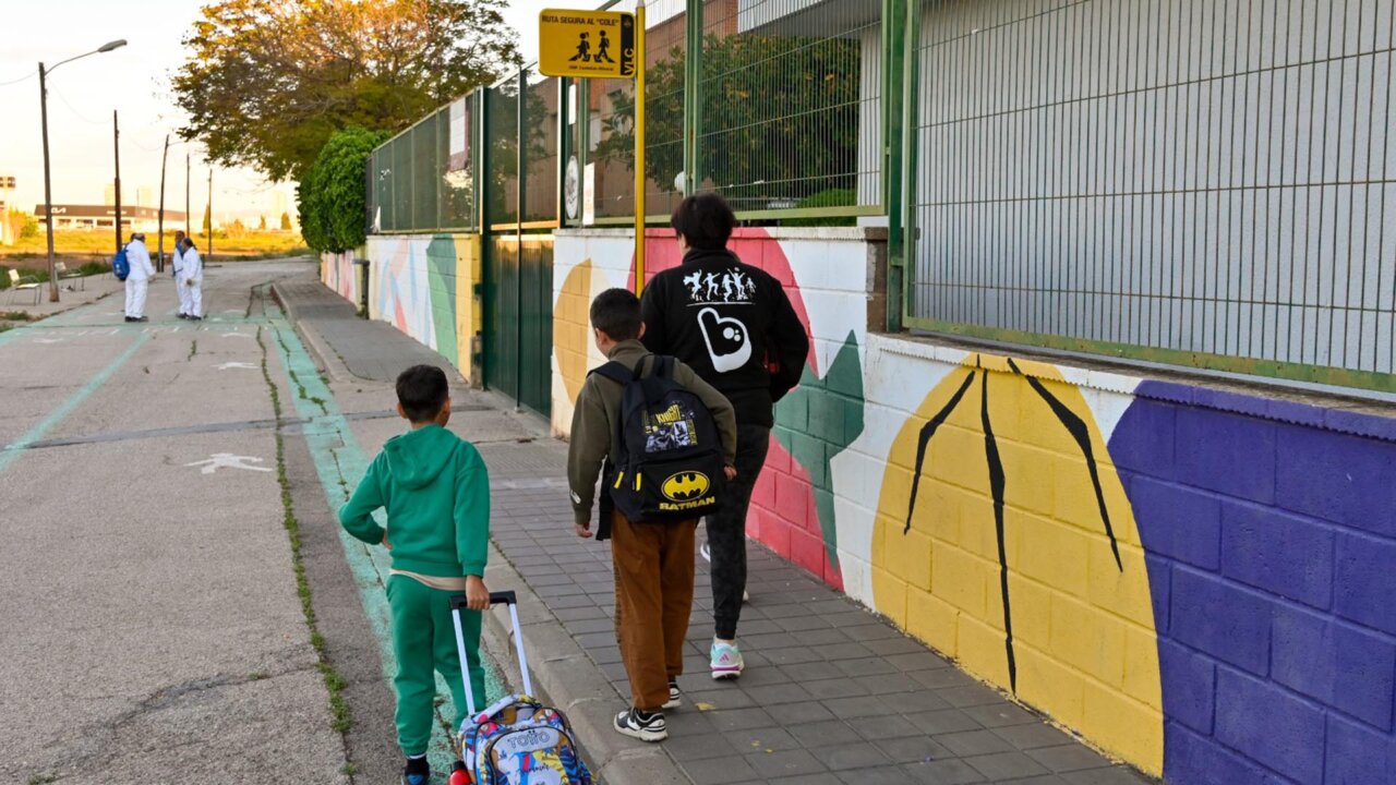 Niños caminando hacia la escuela por una ruta escolar señalizada