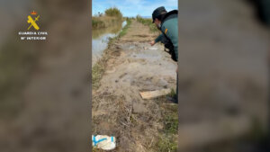 Agentes de la Guardia Civil rescatando a un hombre en lodo en Catarroja