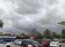 San Vicente Ferrer arranca bajo aviso amarillo marcado por la inestabilidad de madrugada y una clara mejoría por la tarde Cielo nublado con palmeras y coches en un aparcamiento