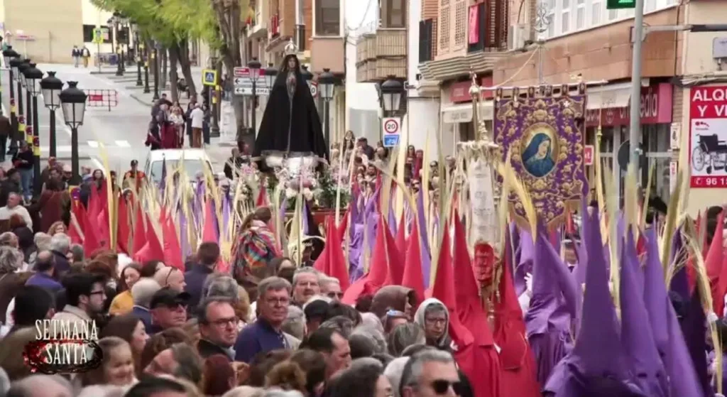 Desfile de Semana Santa en Torrent con cofrades y estandartes