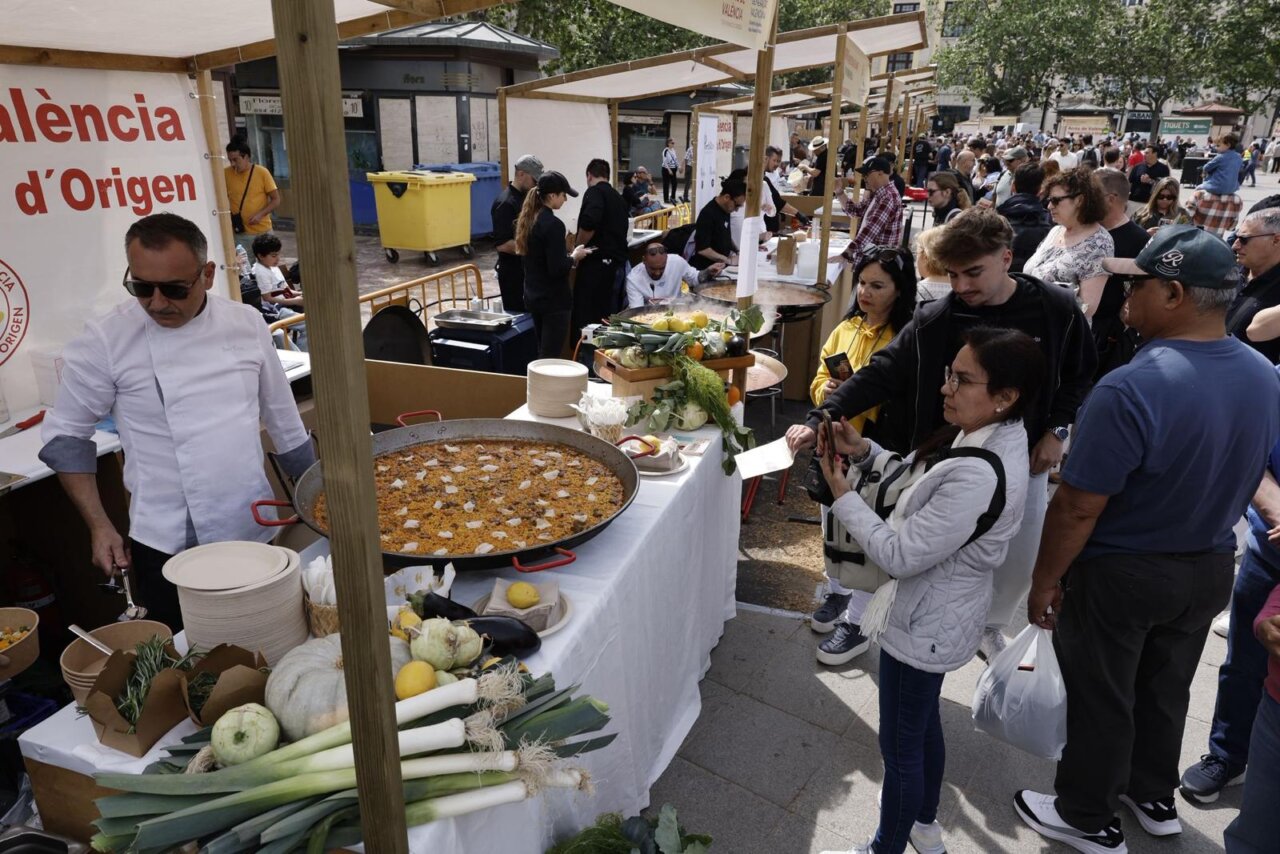 Gente disfrutando del TastArròs en València con paella y verduras frescas