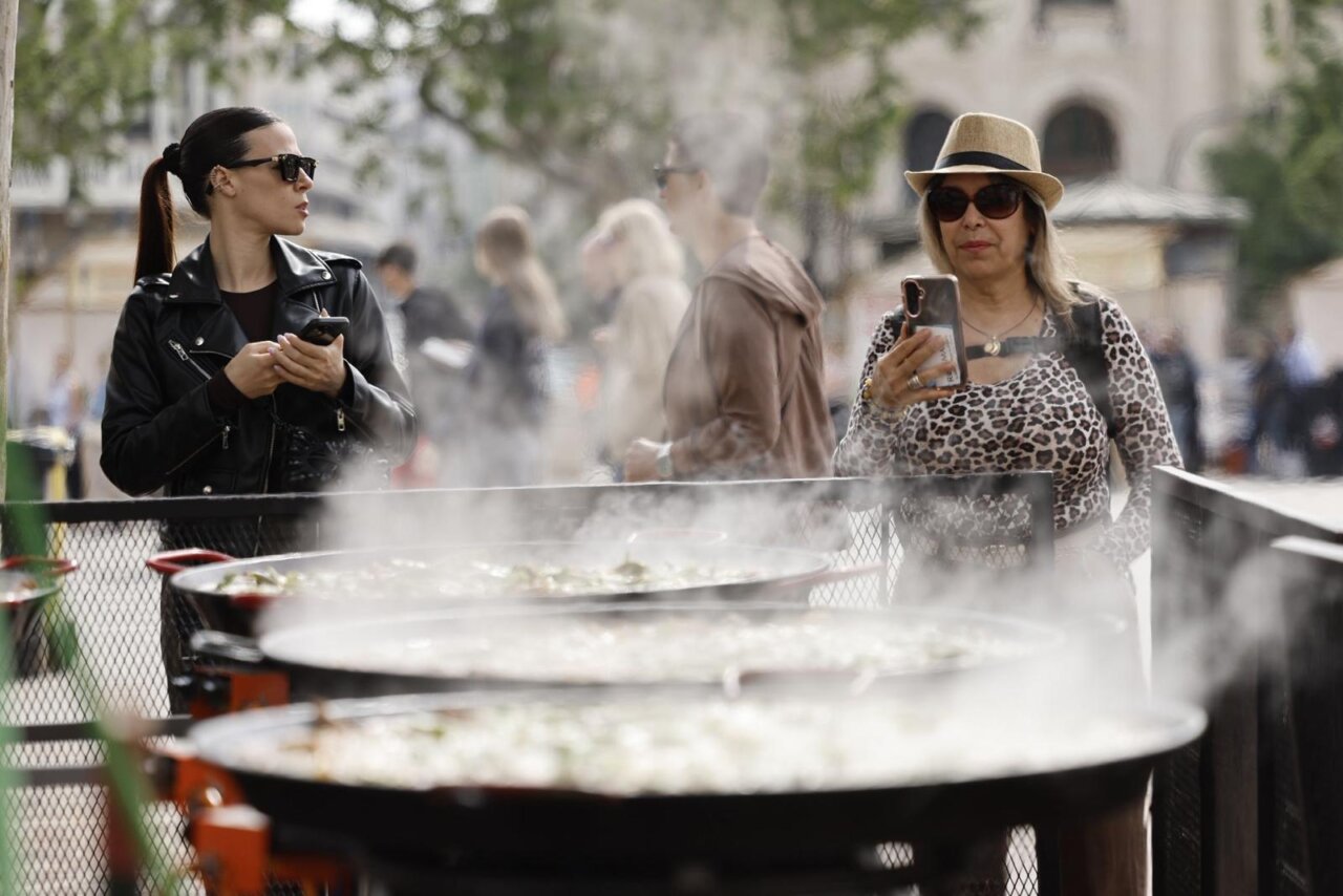 Dos mujeres observando la preparación de paellas en el TastArròs en Valencia