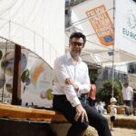 Participante en el TastArròs en València con fondo de carteles informativos