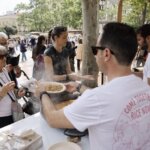 Personas disfrutando del TastArròs en València con platos de arroz