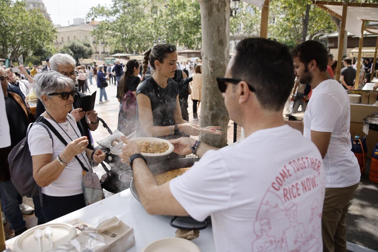 Personas disfrutando del TastArròs en València con platos de arroz