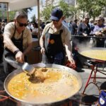 Dos chefs cocinando paella en el evento TastArròs en València