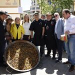 Grupo de personas en el evento TastArròs en València con una gran paella