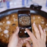 Persona tomando foto de un arroz en concurso de TastArròs