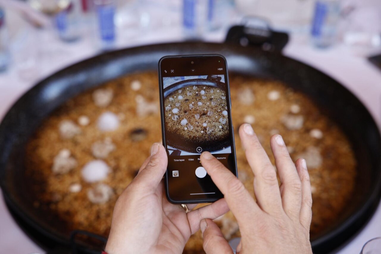 Persona tomando foto de un arroz en concurso de TastArròs