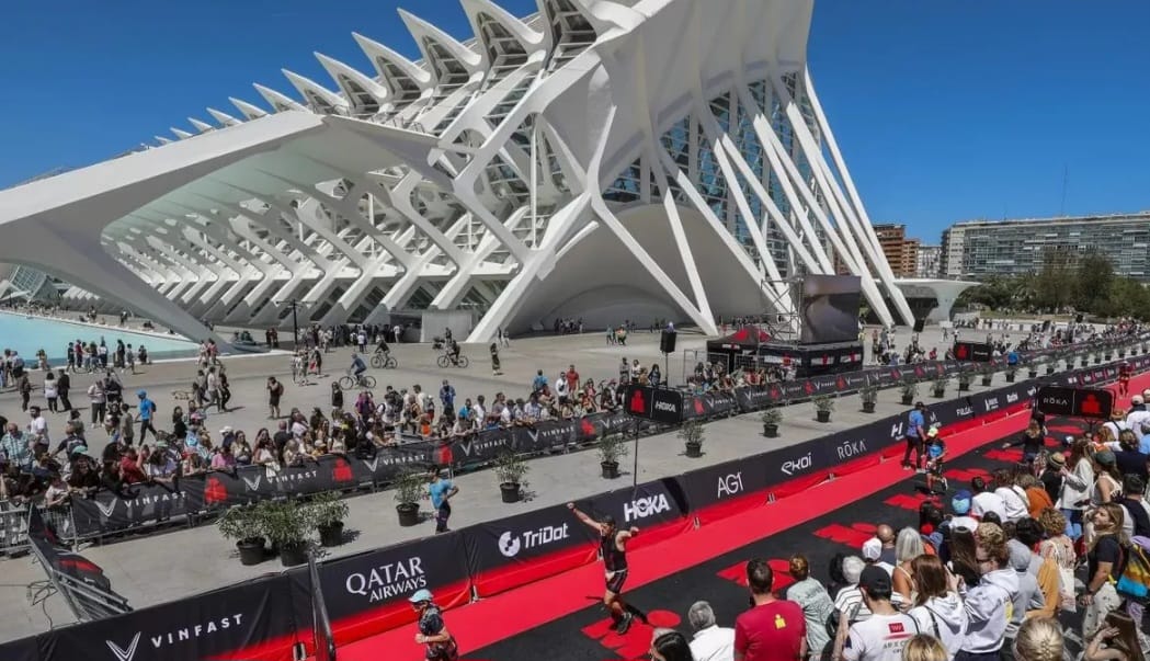 Atletas compitiendo en el triatlón internacional en Valencia con el edificio de la Ciudad de las Artes y las Ciencias de fondo.