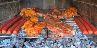 Carne y salchichas asándose en una parrilla durante una torrà popular.