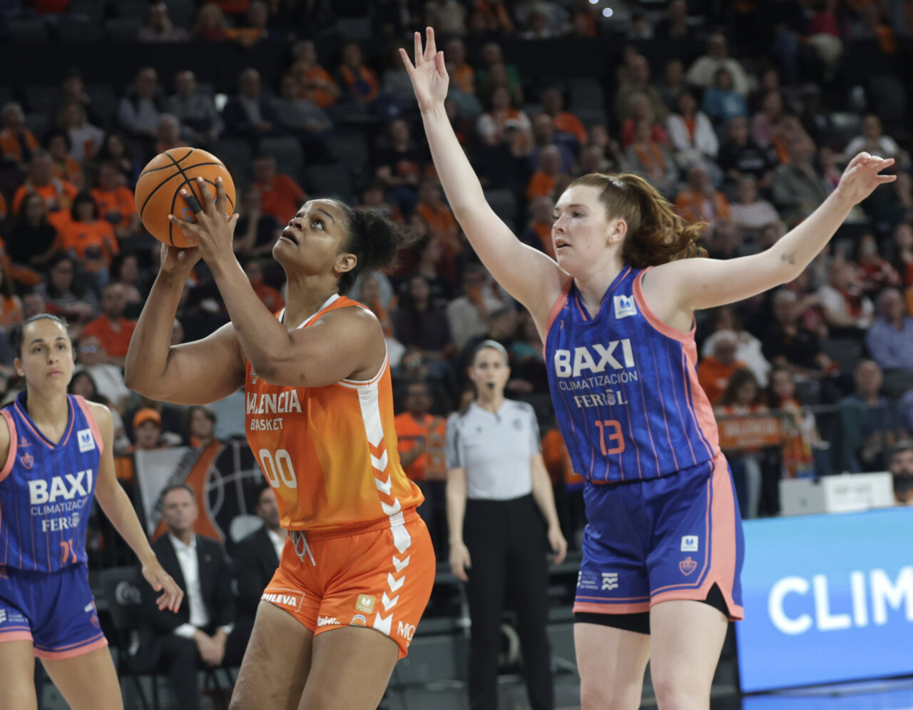 Jugadora de Valencia Basket lanzando a canasta durante un partido emocionante.