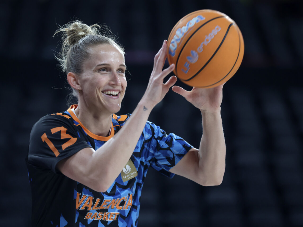 Jugadora del Valencia Basket sonríe mientras sostiene un balón de baloncesto