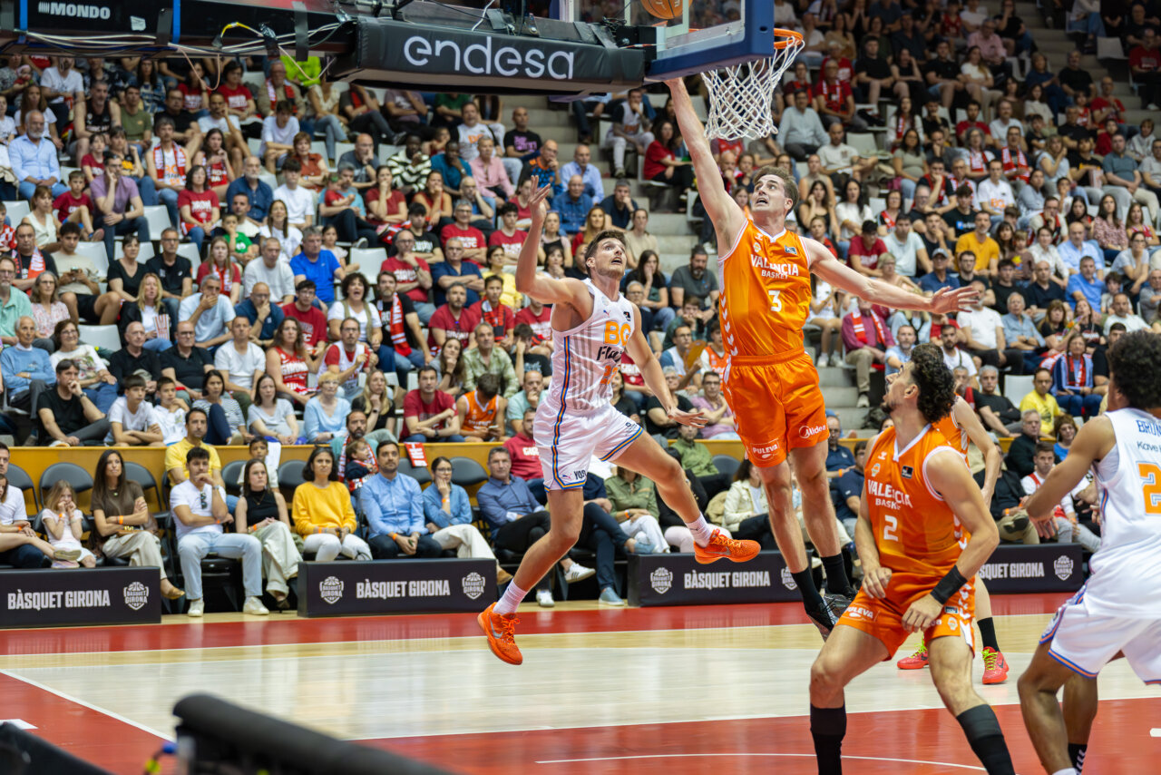Jugadores de Valencia Basket en acción durante un partido emocionante contra Girona