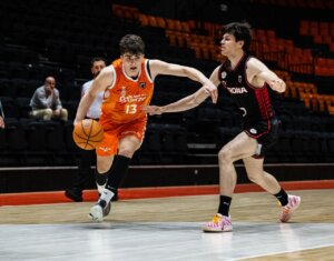 Jugador de Valencia Basket U22 driblando el balón durante un partido contra Girona.