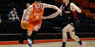Jugador de Valencia Basket U22 driblando el balón durante un partido contra Girona.