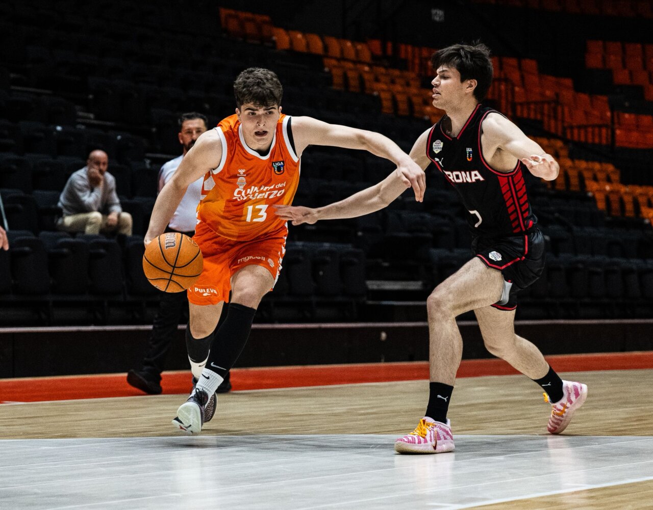 Jugador de Valencia Basket U22 driblando el balón durante un partido contra Girona.