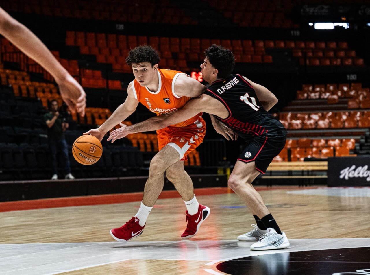 Jugadores de Valencia Basket U22 y Girona compiten por el balón en la cancha.
