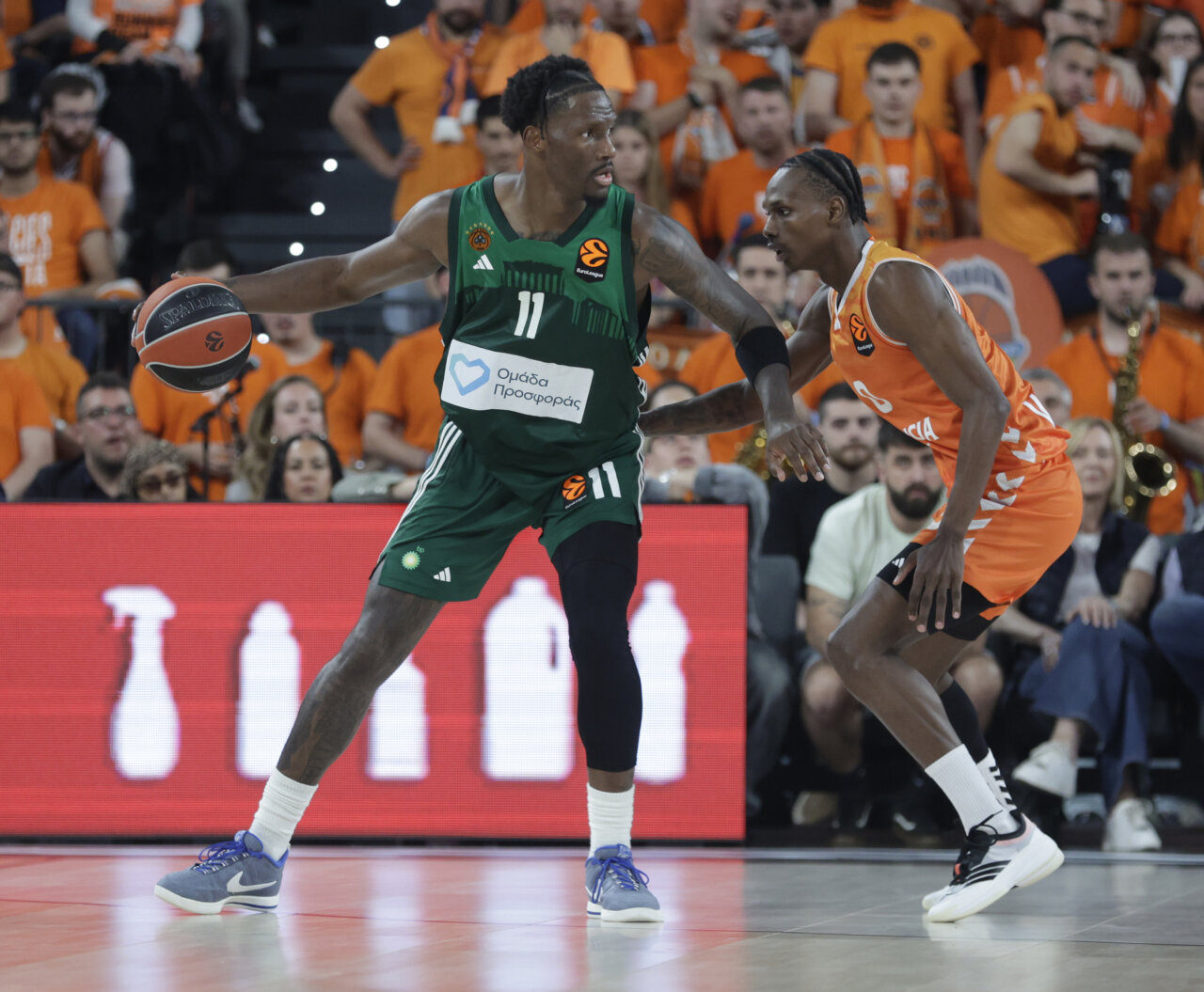 Jugadores de Valencia Basket y Panathinaikos en un intenso partido de baloncesto.