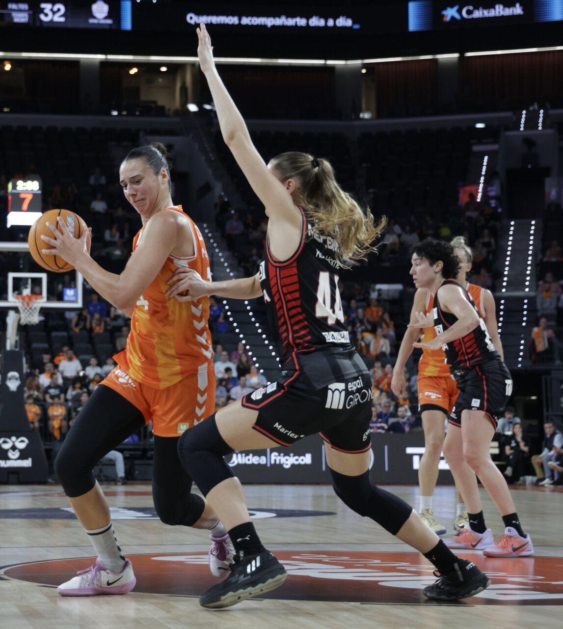 Jugadoras de Valencia Basket y Spar Girona compiten por el balón en un partido intenso.