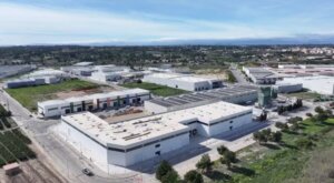Vista aérea de un parque industrial con varias naves y vegetación