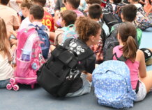 Un verano con más opciones y ahorro para las familias gracias al impulso de Quart de Poblet a la conciliación Grupo de escolares sentados en el suelo con mochilas coloridas