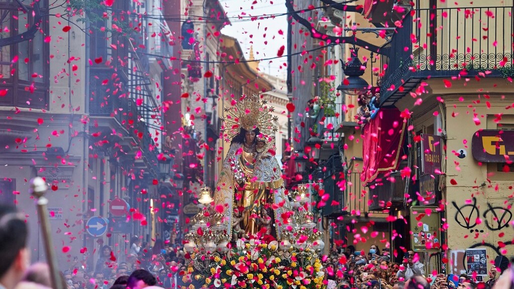 Procesión de la Mare de Déu dels Desemparats con pétalos de flores en el aire.