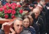 Grupo de personas cargando una cruz decorada con rosas en Valencia