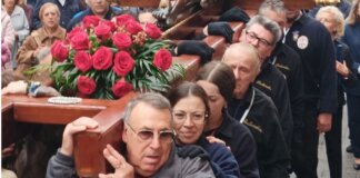 Grupo de personas cargando una cruz decorada con rosas en Valencia