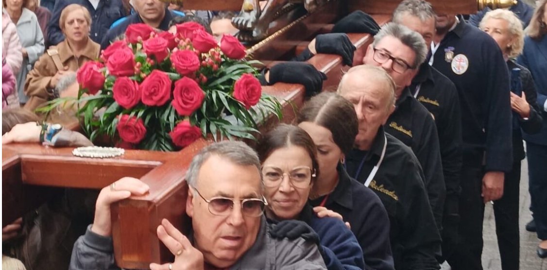 Grupo de personas cargando una cruz decorada con rosas en Valencia