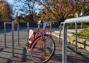 Bicicleta roja estacionada en un soporte urbano