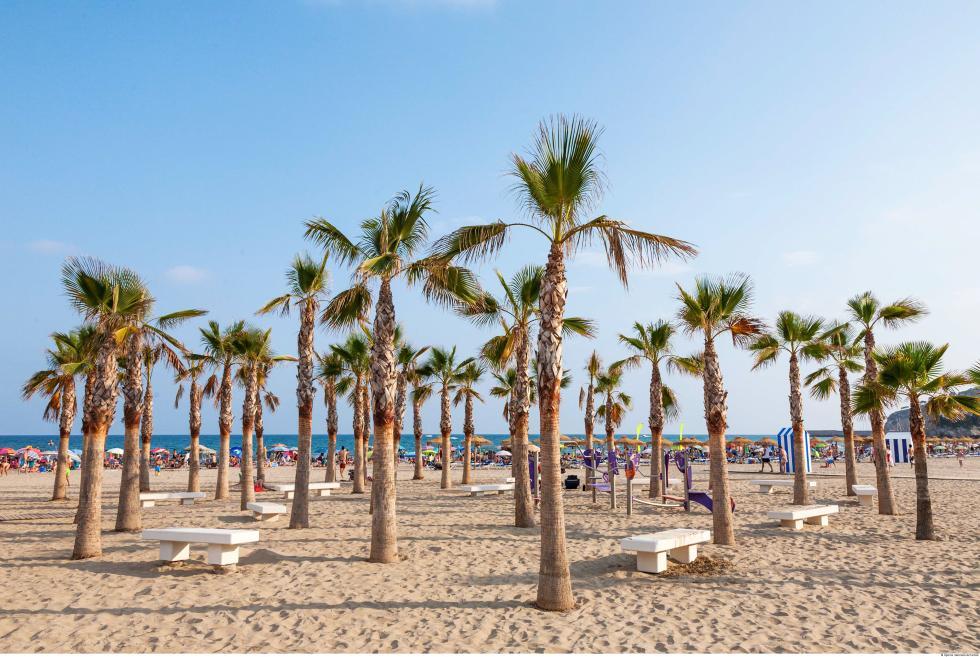Playa del Cabanyal en València con palmeras y sombrillas