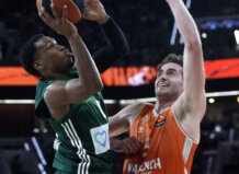 Jugador de Valencia Basket defendiendo a un rival durante un intenso partido de baloncesto.