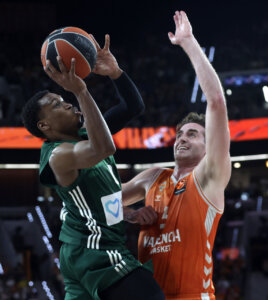 Jugador de Valencia Basket defendiendo a un rival durante un intenso partido de baloncesto.