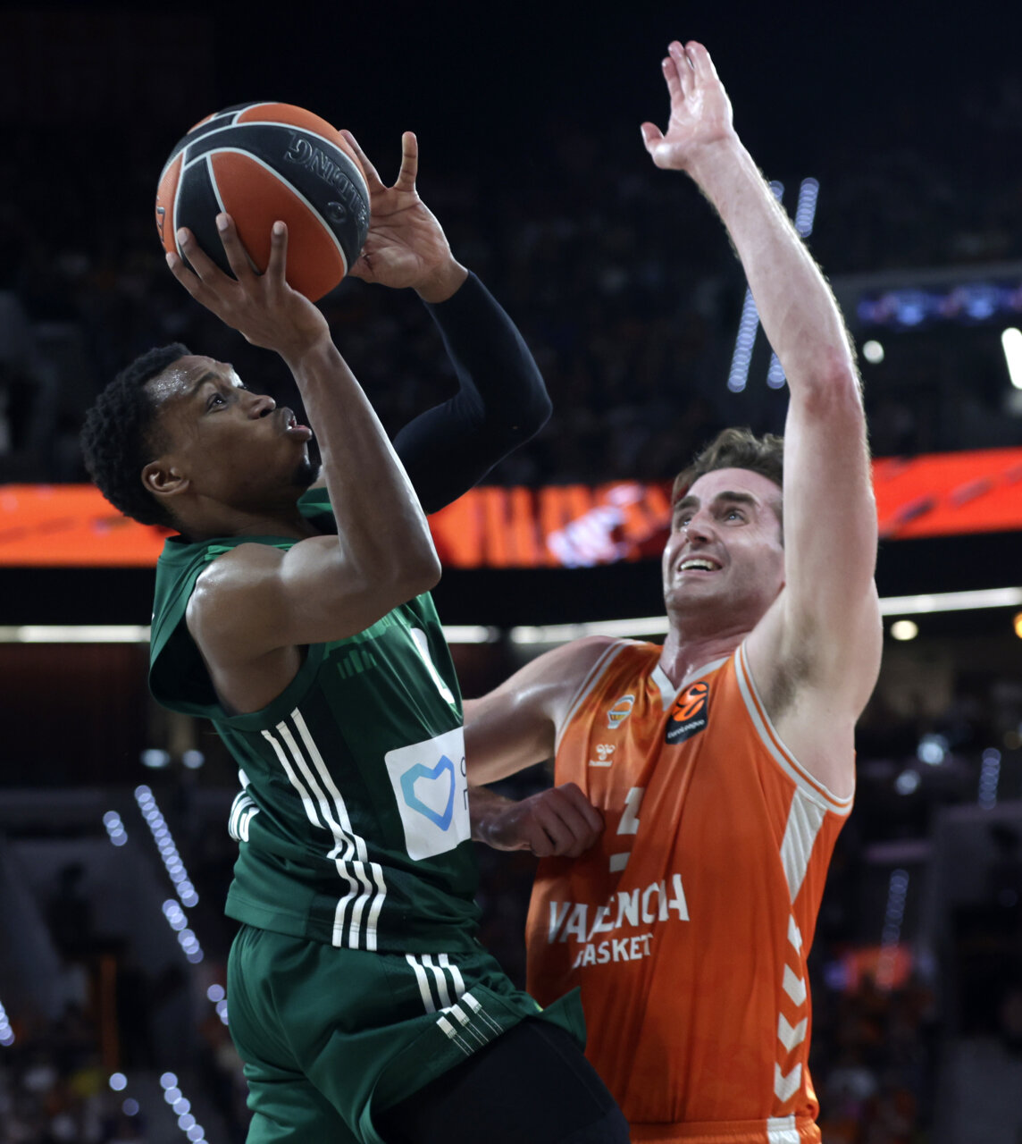Jugador de Valencia Basket defendiendo a un rival durante un intenso partido de baloncesto.