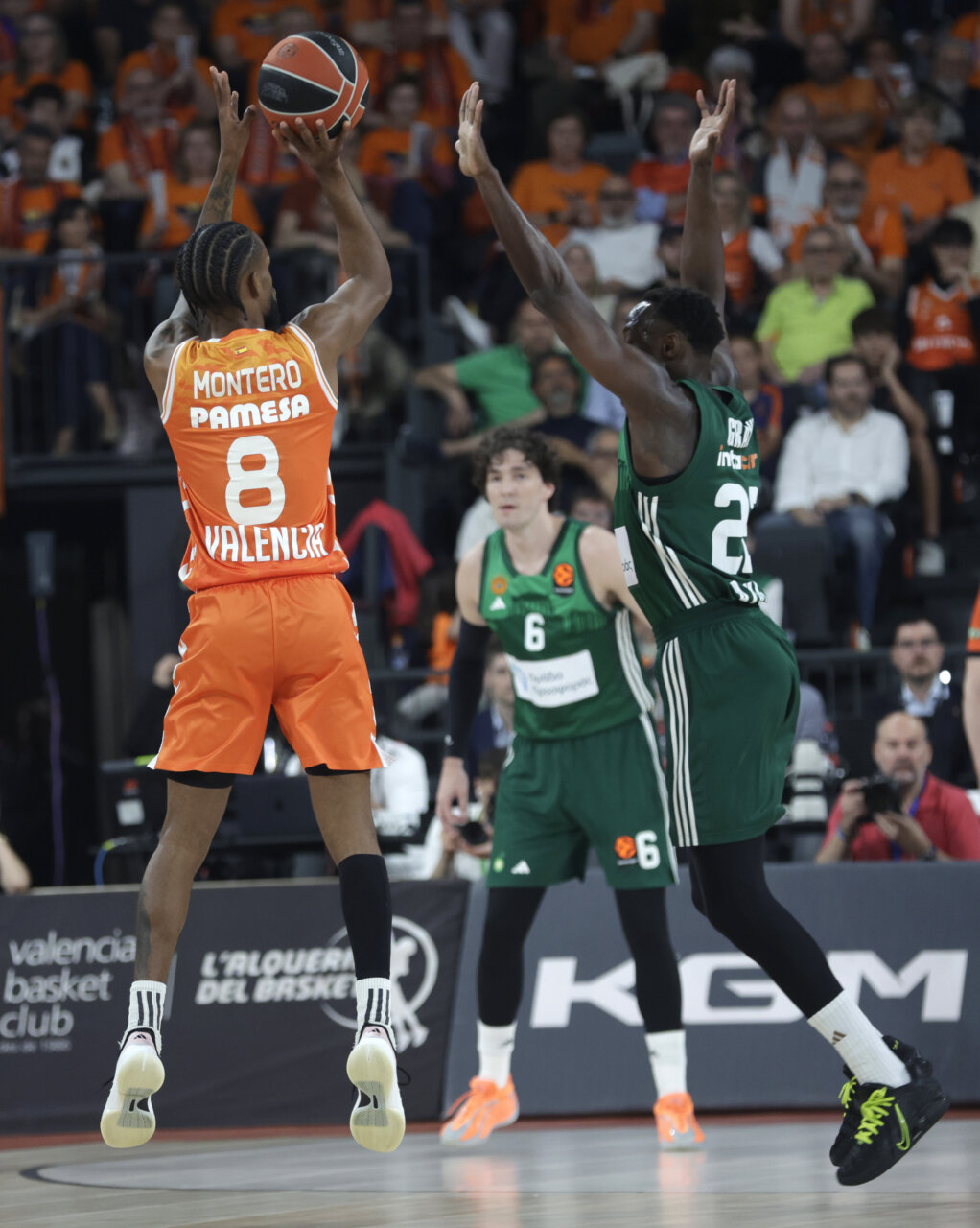 Jugador de Valencia Basket lanzando a canasta durante un partido emocionante.