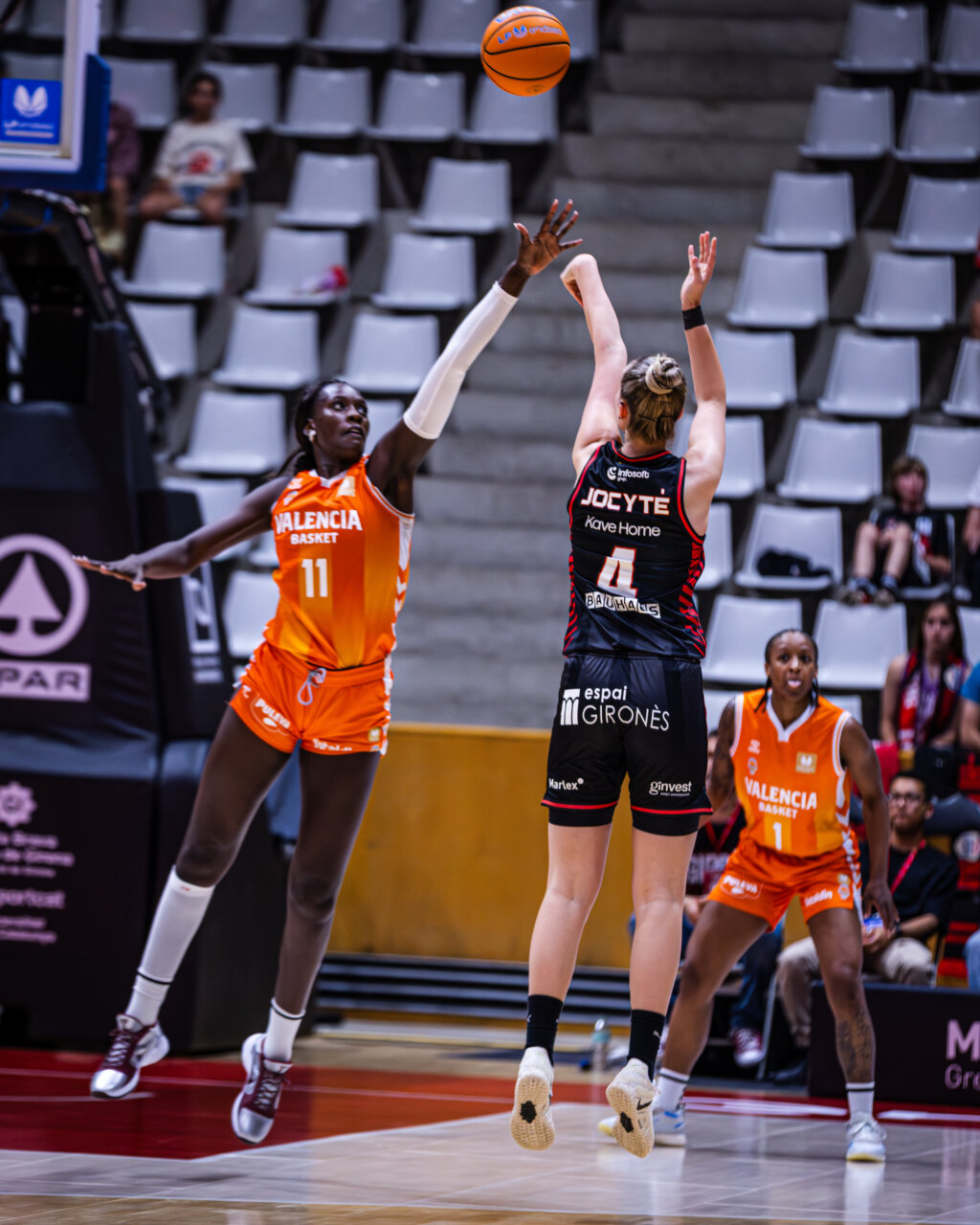 Jugadora de Valencia Basket intenta bloquear un tiro de Spar Girona durante un partido