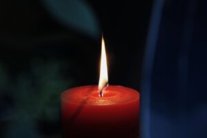 Vela roja encendida en un ambiente oscuro y acogedor