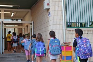 Estudiantes ingresando al CEIP Ramón y Cajal en Xirivella con mochilas