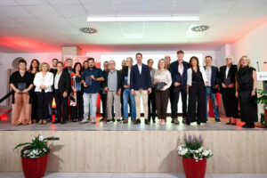 Grupo de personas posa en un escenario con placas de reconocimiento.