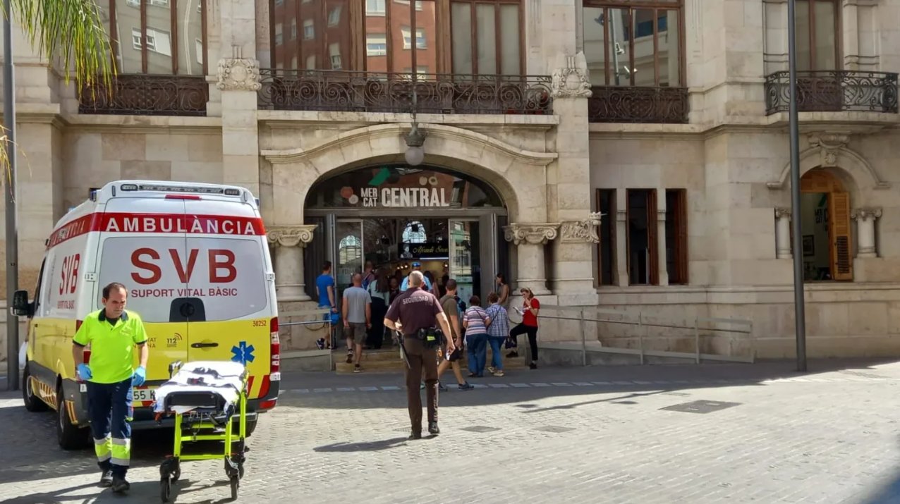 Dos policías auxilian a una pescadera herida en el Mercado Central de València