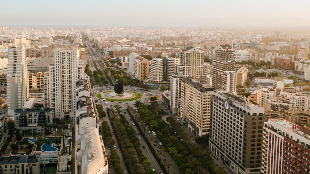 Vista aérea de Valencia con edificios altos, avenidas arboladas y una rotonda